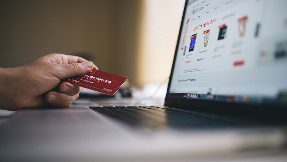 person holding a credit card making an online purchase