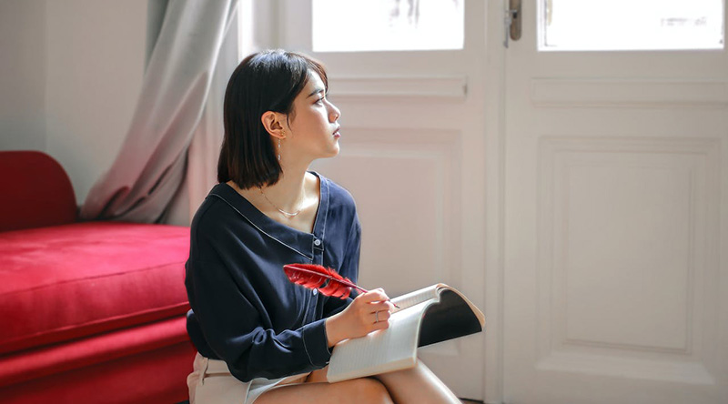 A woman writing on a journal