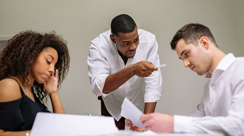 A man shouting at two co-workers