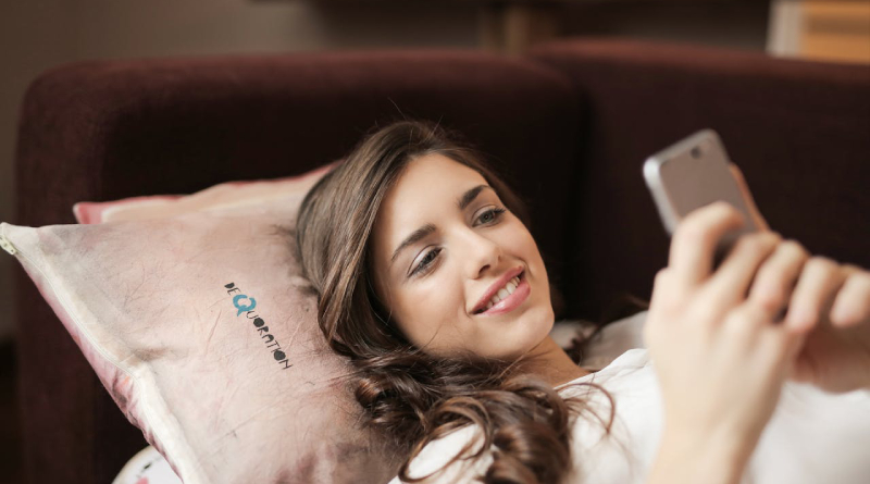 Photo of a woman using her phone while on a couch